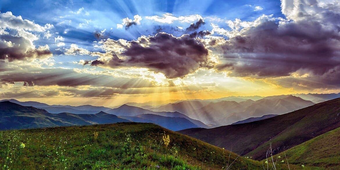 A sunset over green hills