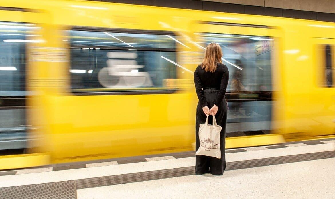 A woman on the platform with a train going past her