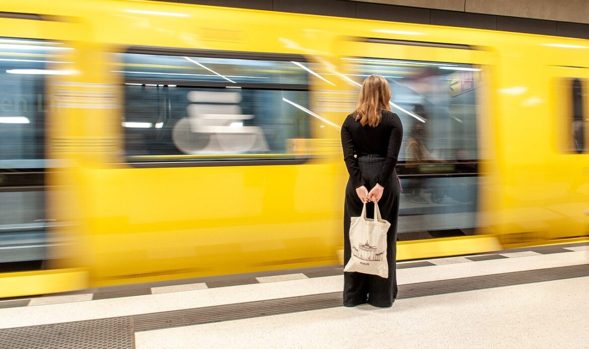 A woman on the platform with a train going past her