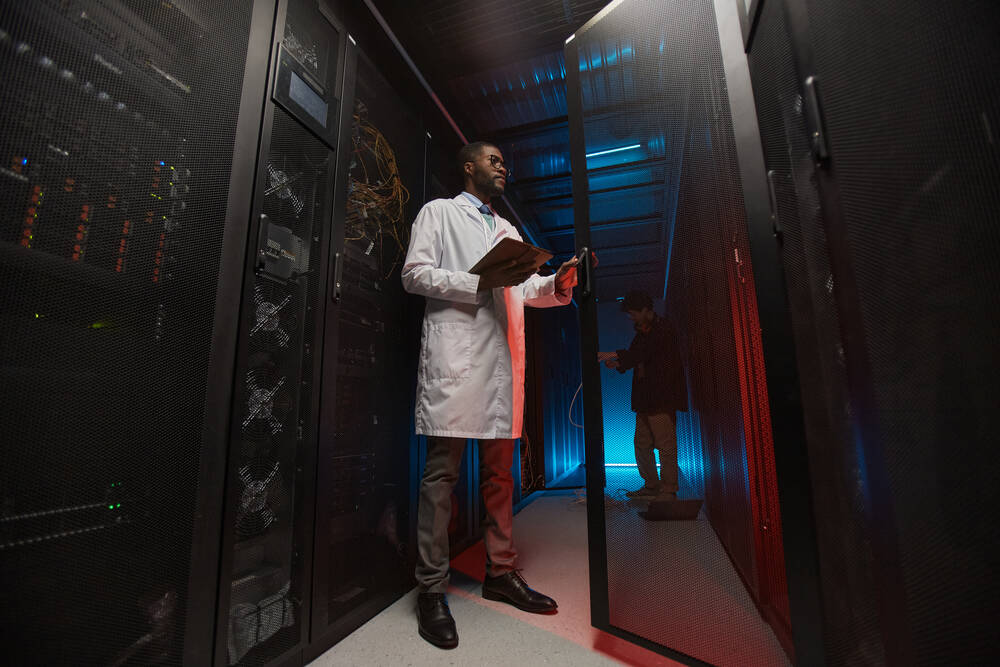 A man in a white coat in a data center