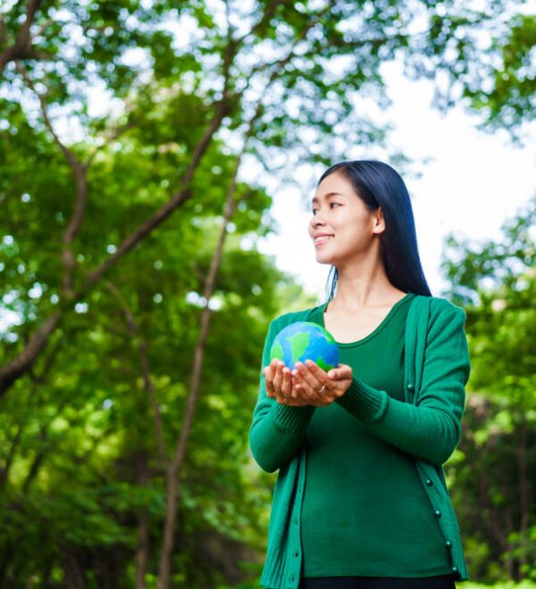 An woman holding a globe in green forest